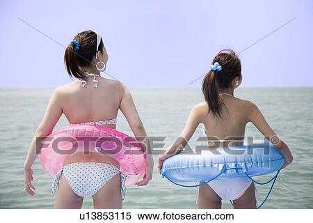 Two young women in bikini standing View Large Photo Image Stock Photography - Two young women in bikini standing. Fotosearch