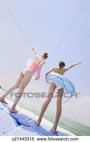 Two young women in bikini standing View Large Photo Image Stock Photography - Two young women in bikini standing. Fotosearch