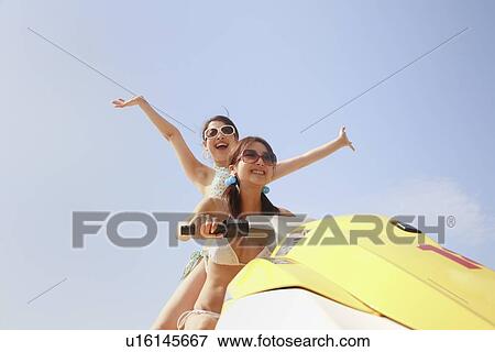 Stock Photo - Two young women jet-skiing. Fotosearch