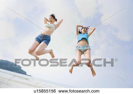 Stock Photograph - Two young women jumping. Fotosearch