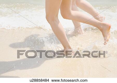 Two young women running at beach View Large Photo Image Picture - Two young women running at beach. Fotosearch