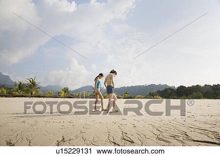 Two young women walking at beach View Large Photo Image Stock Image - Two young women walking at beach. Fotosearch