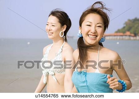 Two young women walking at beach View Large Photo Image Stock Photography - Two young women walking at beach. Fotosearch
