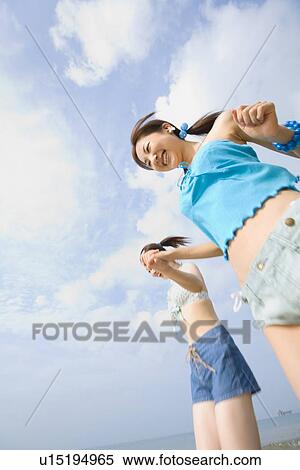 Stock Photography - Two young women walking at beach. Fotosearch