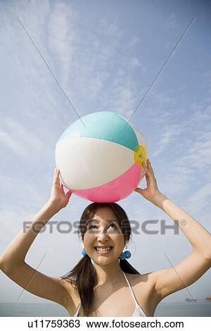 Young woman holding with beach ball View Large Photo Image Stock Image - Young woman holding with beach ball. Fotosearch