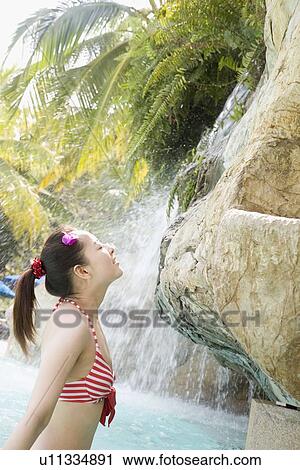 Young woman in bikini relaxing in pool View Large Photo Image Stock Image - Young woman in bikini relaxing in pool. Fotosearch