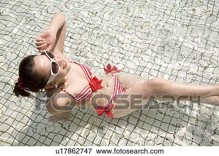 Young woman in bikini sitting in pool View Large Photo Image Stock Photo - Young woman in bikini sitting in pool. Fotosearch
