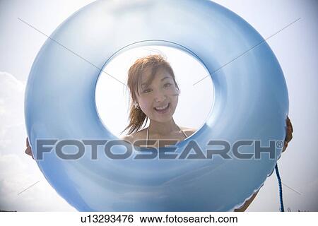 Young woman looking through inner tube View Large Photo Image Stock Photograph - Young woman looking through inner tube. Fotosearch