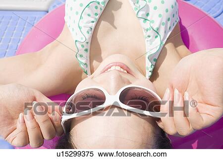 Stock Photography - Young woman sunbathing. Fotosearch
