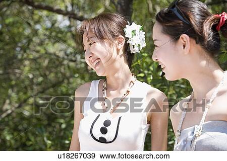 Two young women smiling View Large Photo Image Stock Photo - Two young women smiling. Fotosearch