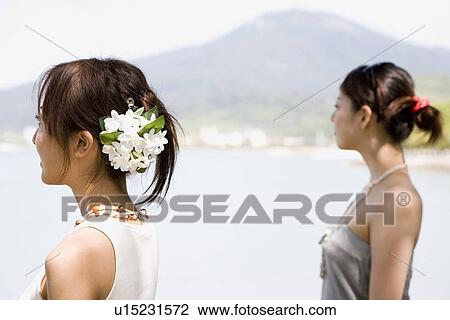 Two young women standing at beach View Large Photo Image Stock Image - Two young women standing at beach. Fotosearch
