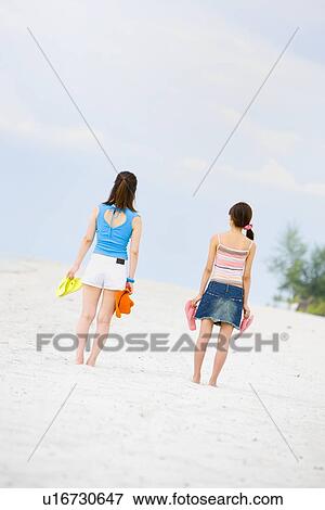 Two young women standing at beach View Large Photo Image Stock Photo - Two young women standing at beach. Fotosearch