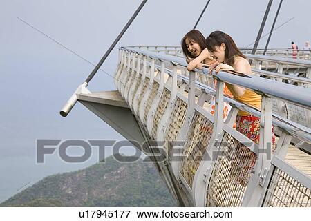 Two young women standing at observatory View Large Photo Image Stock Photo - Two young women standing at observatory. Fotosearch