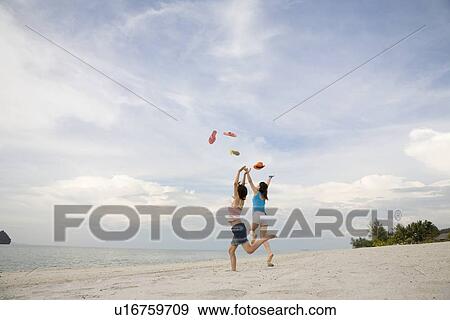 Stock Photo - Two young women throwing flip flop. Fotosearch