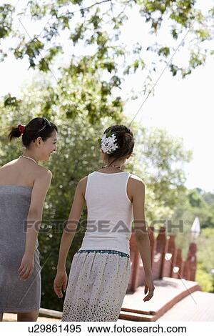 Two young women walking View Large Photo Image Stock Photography - Two young women walking. Fotosearch