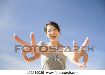Young woman making peace sign View Large Photo Image Stock Photo - Young woman making peace sign. Fotosearch