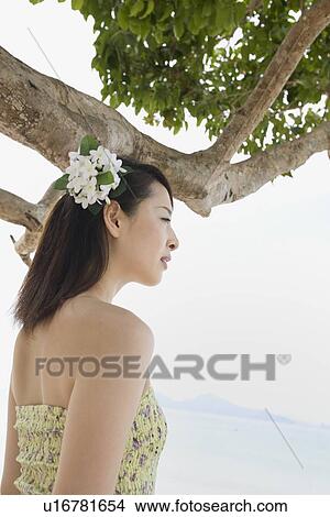 Young woman standing at beach View Large Photo Image Picture - Young woman standing at beach. Fotosearch