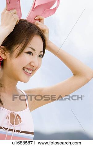 Young woman standing at beach View Large Photo Image Stock Image - Young woman standing at beach. Fotosearch