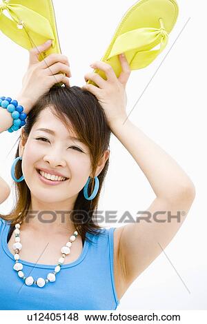 Stock Photo - Young woman standing at beach. Fotosearch