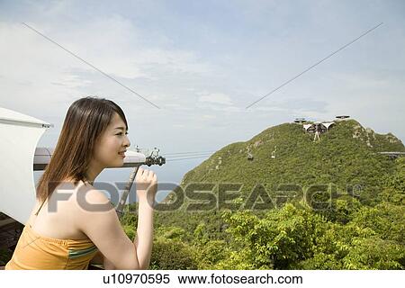 Stock Photography - Young woman standing at observatory. Fotosearch