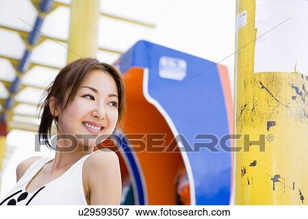 Young woman standing in front of pay phone View Large Photo Image Stock Photo - Young woman standing in front of pay phone. Fotosearch
