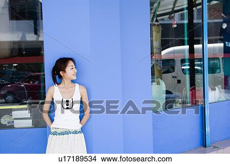 Picture - Young woman standing in front of shop. Fotosearch