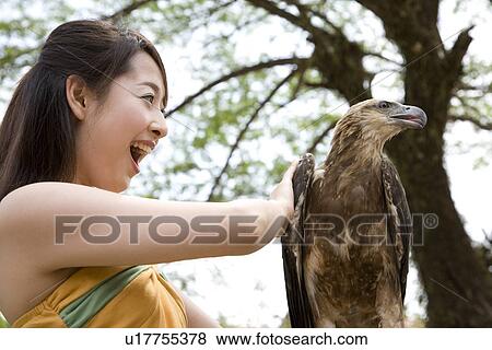 Stock Photo - Young woman touching eagle. Fotosearch