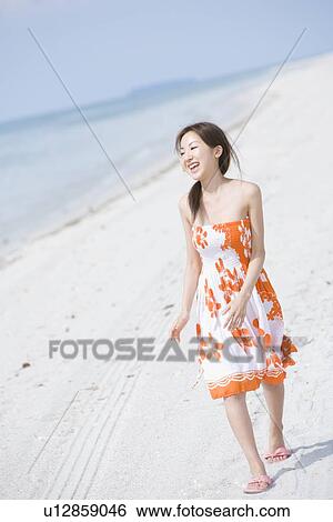 Young woman walking at beach View Large Photo Image Stock Photograph - Young woman walking at beach. Fotosearch