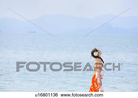 Stock Photograph - Young woman walking at beach. Fotosearch