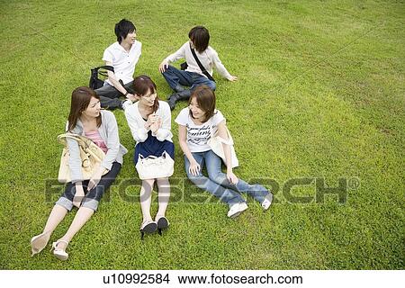 Picture - College students sitting on lawn. Fotosearch