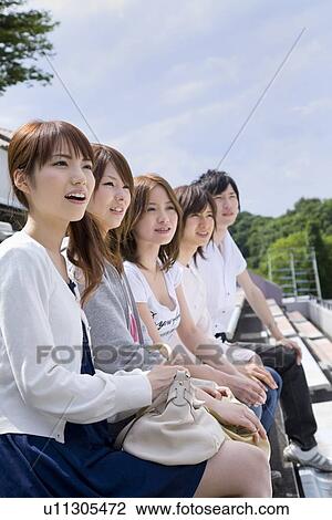 Stock Image - College students watching game at stadium. Fotosearch