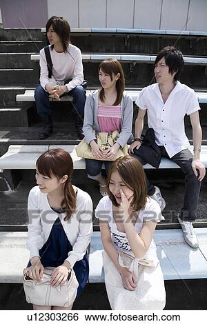 Stock Photograph - College students watching game at stadium. Fotosearch