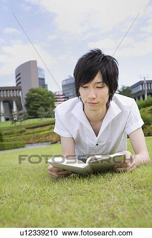 Stock Image - Young man reading book. Fotosearch