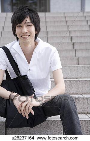 Young man sitting on steps View Large Photo Image Picture - Young man sitting on steps. Fotosearch