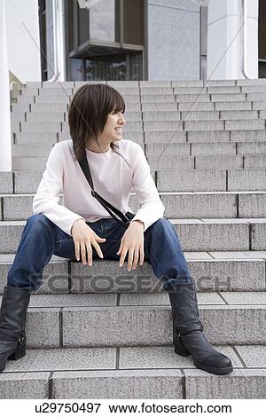 Stock Photo - Young man sitting on steps. Fotosearch