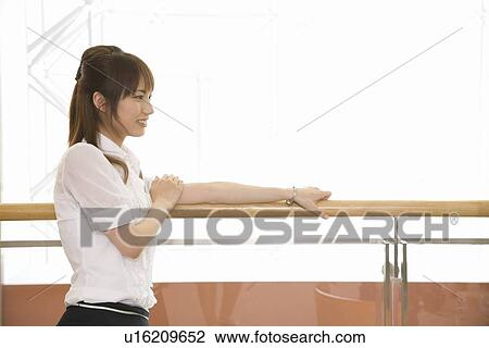 Young woman leaning against railing View Large Photo Image Stock Image - Young woman leaning against railing. Fotosearch