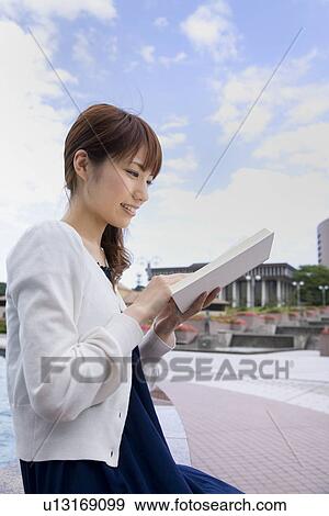Stock Photo - Young woman reading book. Fotosearch