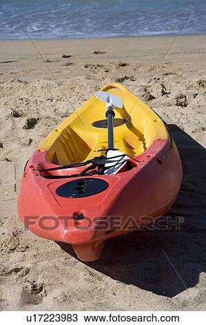 Stock Image - A boat with red and yellow color on the beach. Fotosearch