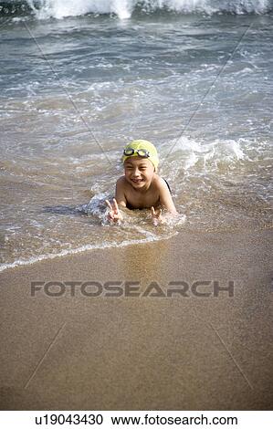 A little boy lying on the sand and smiling happily View Large Photo Image Stock Image - A little boy lying on the sand and smiling happily. Fotosearch