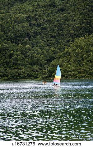A multicolored sailboat floating on the water View Large Photo Image Stock Photograph - A multicolored sailboat floating on the water. Fotosearch