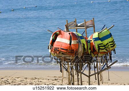 A stack of life vests hanging on the iron shelf at beach View Large Photo Image Stock Image - A stack of life vests hanging on the iron shelf at beach. Fotosearch