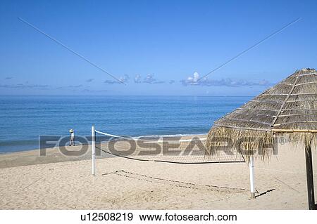A thatched sunshade and a volleyball net on the seaside View Large Photo Image Stock Photo - A thatched sunshade and a volleyball net on the seaside. Fotosearch