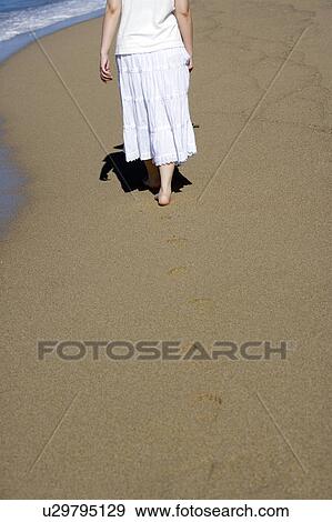 A woman is walking on the sand, lower section View Large Photo Image Stock Photo - A woman is walking on the sand, lower section. Fotosearch