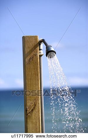 Stock Photography - Close-up of a shower head at beach. Fotosearch