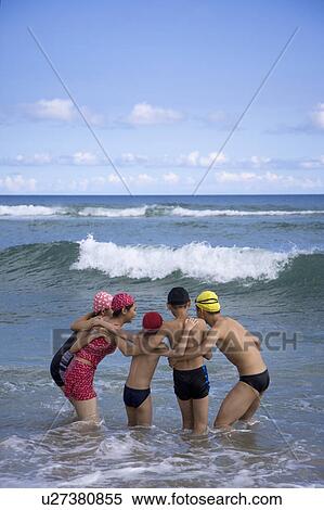 Stock Photography - Five people standing in the sea. Fotosearch