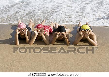 Four children lying on the sand and making the OK sign View Large Photo Image Stock Image - Four children lying on the sand and making the OK sign. Fotosearch