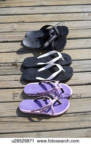 Three pairs of slipper on the wooden board View Large Photo Image Stock Image - Three pairs of slipper on the wooden board. Fotosearch