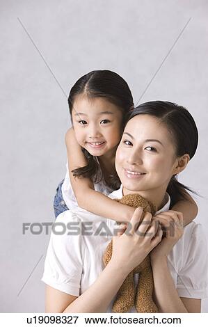 Daughter holding mother tightly and looking at the camera View Large Photo Image Stock Photo - Daughter holding mother tightly and looking at the camera. Fotosearch