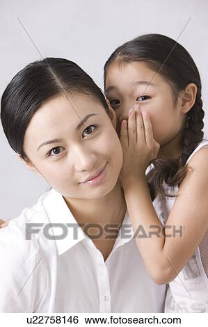 Daughter telling something secretly to her mother View Large Photo Image Stock Photograph - Daughter telling something secretly to her mother. Fotosearch