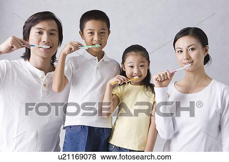 Family with two children brushing teeth and looking at the camera, in a row View Large Photo Image Stock Photo - Family with two children brushing teeth and looking at the camera, in a row. Fotosearch